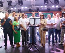 O governador Ratinho Júnior mostra contrato assinado com financiamento para empresa da cidade de Porto Rico, acompanhado do diretor presidente da Fomento Paraná, Heraldo Neves, e outras autoridades.