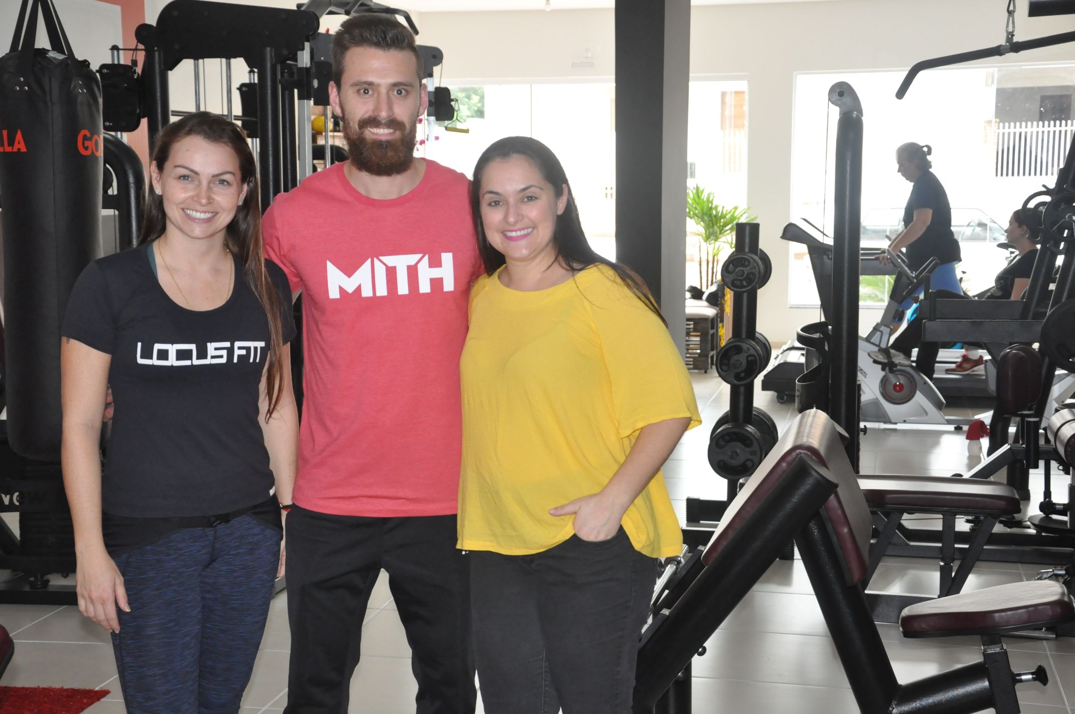 A profissional de educação física buscou financiamento da Fomento Paraná para montar a academia, inaugurada em maio de 2017. Na imagem, com o noivo Thiago Cogo e com a agente de crédito Karoline Hoffmann.