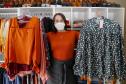 A empresária Josiane Duarte, proprietária de uma loja de roupas para o público evangélico, em Piraquara. Na foto ela mostra roupas coloridas e escuras.