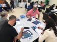 Atividade dinâmica com agentes sentados em mesas durante o Encontro regional de agentes de crédito da Fomento Paraná em Curitiba.