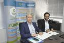 Jorge Callado, do Ipardes, e Heraldo Neves, da Fomento Paraná, assinam documento de entrega do estudo que mediu impacto do crédito na economia paranaense