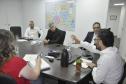 Reunião entre diretores da Fomento paraná e do BDMG em uma sala com uma grande mesa de reuniões