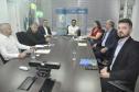 Reunião entre diretores da Fomento paraná e do BDMG em uma sala com uma grande mesa de reuniões