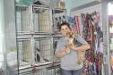 Empreendedora dona de um petshop posa para foto com cãozinho no colo.