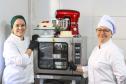 Neusa (à direita), como novo forno e batedeira da empresa familiar adquiridos com financiamento da Fomento Paraná por intermédio da Prefeitura de Curitiba.