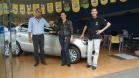 Agente de crédito Reinaldo Ribeiro acompanha os taxistas Estevan Cezar de Oliveira e Rosinei Veronez de Aguiar ao receberem as chaves dos novos veículos.