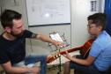 O professor Rodrigo Haniskievicz orienta o aluno Alexandre Pinheiro Neto. Local atende estudantes de música de todas as idades. Empreendedor usou a linha da Fomento Paraná, desenvolvida em parceria com a Secretaria de Estado da Cultura para apoiar empreendimentos da economia criativa.