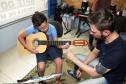 O professor Rodrigo Haniskievicz orienta o aluno Alexandre Pinheiro Neto. Local atende estudantes de música de todas as idades. Empreendedor usou a linha da Fomento Paraná, desenvolvida em parceria com a Secretaria de Estado da Cultura para apoiar empreendimentos da economia criativa.