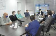 Diretores da Fomento Paraná em reunião com equipe da diretoria e técnicos da Goiás Fomento, em sala de reunião.