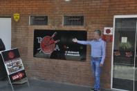 Empresário Ailton Trevisolo posa para foto diante da fachada de seu restaurante.