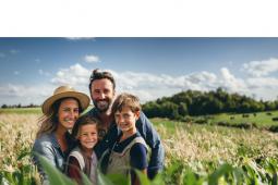 Uma família de produtores rurais num campo de plantação de milho.