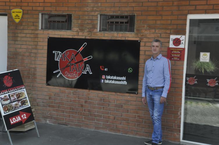 Ailton Trevisolo diante da fachada do restaurante Taka Taka Sushi.