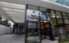 Imagem da fachada da sede da Fomento Paraná em Curitiba. É uma parede envidraçada em módulos tipo fumê com logotipos da Fomento, Invest e Governo