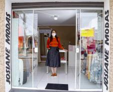  empresária Josiane Duarte, proprietária de uma loja de roupas para o público evangélico, em Piraquara. Na foto ela está dentro da loja, que é uma vitrine com porta no meio, e dá para ver as roupas na loja.