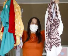 A empresária Josiane Duarte, proprietária de uma loja de roupas para o público evangélico, em Piraquara. Na foto ela mostra roupas claras e coloridas.