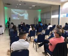 Encontro de Agentes em Ponta Grossa. Pessoas sentadas em pequeno auditório de costas para a foto enquanto alguém fala.