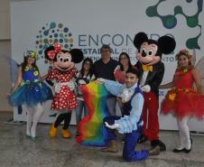 Encontro de Agentes de Crédito em Foz do Iguaçu - agentes de crédito e de desenvolvimento posam para foto em frente a um painel com animadores vestidos de personagens Disney..