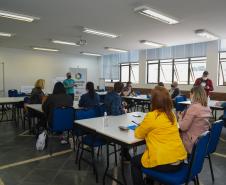 Encontro de agentes de crédito em Curitiba. Pessoas sentadas em grupos ouvem palestra