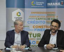 Jorge Callado, do Ipardes, e Heraldo Neves, da Fomento Paraná, assinam documento de entrega do estudo que mediu impacto do crédito na economia paranaense