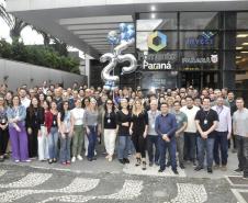 A imagem mostra grupo de mais de 100 colaboradores da Fomento Paraná posando para foto em frente à empresa