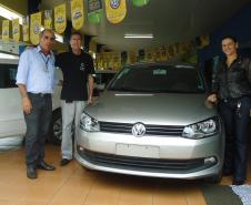 Agente de crédito Reinaldo Ribeiro acompanha os taxistas Estevan Cezar de Oliveira e Rosinei Veronez de Aguiar ao receberem as chaves dos novos veículos.