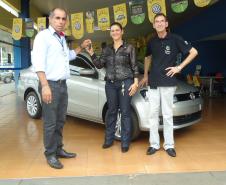 Agente de crédito Reinaldo Ribeiro acompanha os taxistas Estevan Cezar de Oliveira e Rosinei Veronez de Aguiar ao receberem as chaves dos novos veículos.