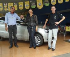 Agente de crédito Reinaldo Ribeiro acompanha os taxistas Estevan Cezar de Oliveira e Rosinei Veronez de Aguiar ao receberem as chaves dos novos veículos.