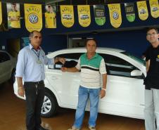 Agente de crédito Reinaldo Ribeiro acompanha os taxistas Estevan Cezar de Oliveira e Rosinei Veronez de Aguiar ao receberem as chaves dos novos veículos.