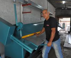 Edilson de Lima, em Foz do Iguaçu, com sua nova máquina de dobrar calhas, comprada com um financiamento de microcrédito da Fomento Paraná.
