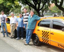 Os taxistas Artur e Márcio Ergang, com carros financiados pela linha Banco do Empreendedor Taxistas, da Fomento Paraná, junto com colegas taxistas, em Curitiba.