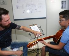 O professor Rodrigo Haniskievicz orienta o aluno Alexandre Pinheiro Neto. Local atende estudantes de música de todas as idades. Empreendedor usou a linha da Fomento Paraná, desenvolvida em parceria com a Secretaria de Estado da Cultura para apoiar empreendimentos da economia criativa.