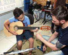 O professor Rodrigo Haniskievicz orienta o aluno Alexandre Pinheiro Neto. Local atende estudantes de música de todas as idades. Empreendedor usou a linha da Fomento Paraná, desenvolvida em parceria com a Secretaria de Estado da Cultura para apoiar empreendimentos da economia criativa.