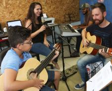 Escola de Palmeira atende estudantes de música de todas as idades. Empreendedor usou a linha da Fomento Paraná, desenvolvida em parceria com a Secretaria de Estado da Cultura para apoiar empreendimentos da economia criativa. Na imagem, os alunos Alexandre Pinheiro Neto e Paloma de Jesus Cubas com o professor Rodrigo Haniskievicz e Webis Duarte (ao fundo).