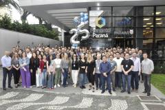 A imagem mostra grupo de mais de 100 colaboradores da Fomento Paraná posando para foto em frente à empresa