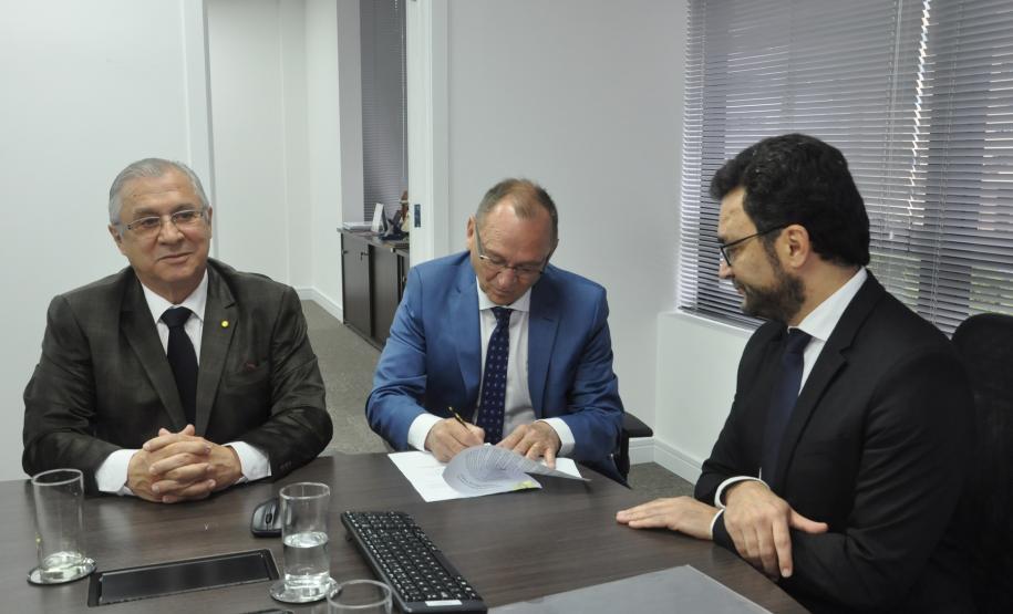 O novos diretores Éverton Ribeiro e Nildo Lübke assinam termo de posse na Fomento Paraná