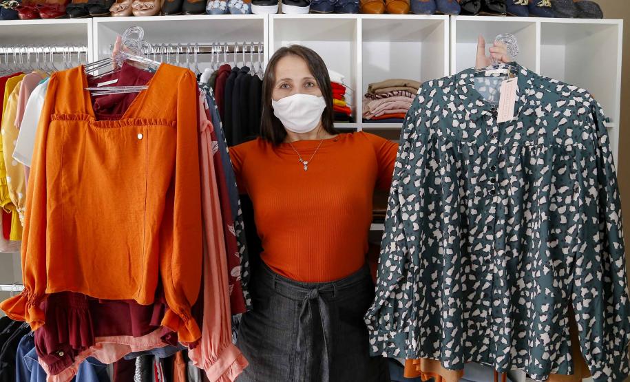 A empresária Josiane Duarte, proprietária de uma loja de roupas para o público evangélico, em Piraquara. Na foto ela mostra roupas coloridas e escuras.