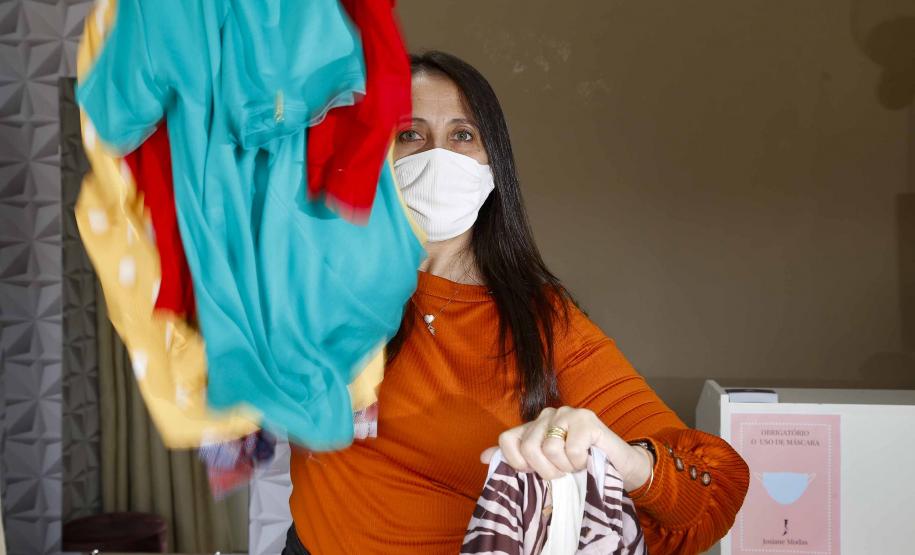 A empresária Josiane Duarte, proprietária de uma loja de roupas para o público evangélico, em Piraquara. Na foto ela mostra roupas claras e coloridas.