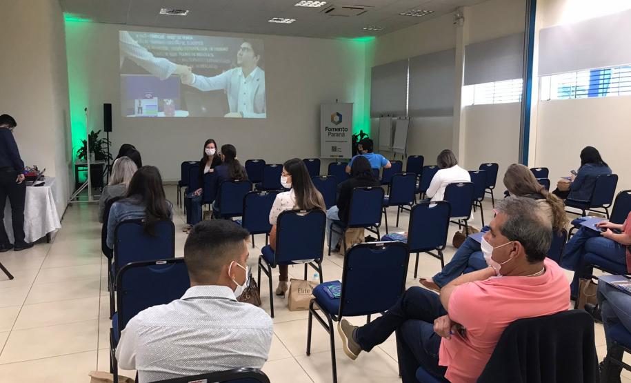Encontro de Agentes em Ponta Grossa. Pessoas sentadas em pequeno auditório de costas para a foto enquanto alguém fala.