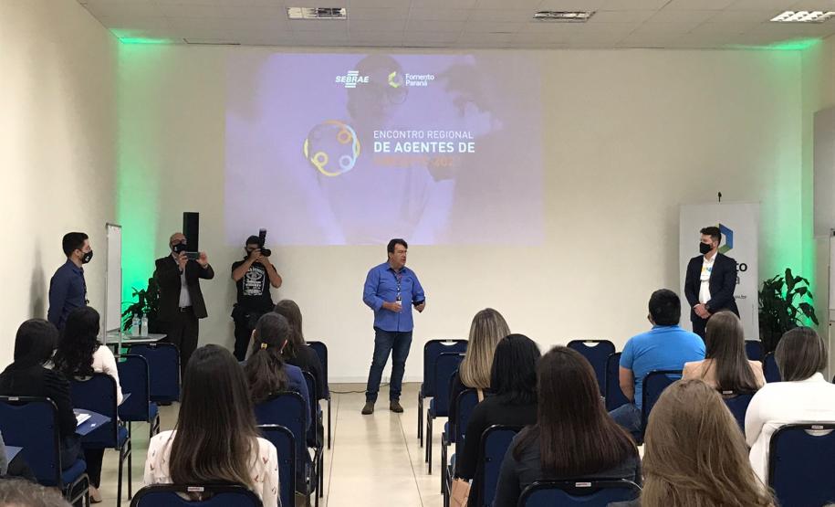 Encontro de Agentes em Ponta Grossa. Pessoas sentadas em pequeno auditório de costas para a foto enquanto alguém fala.