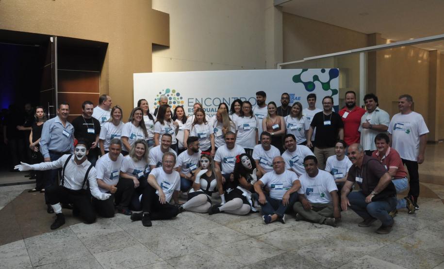 Encontro de Agentes de Crédito em Foz do Iguaçu - agentes de crédito e de desenvolvimento agrupados em duas fileiras, posam para foto em frente a um painel.