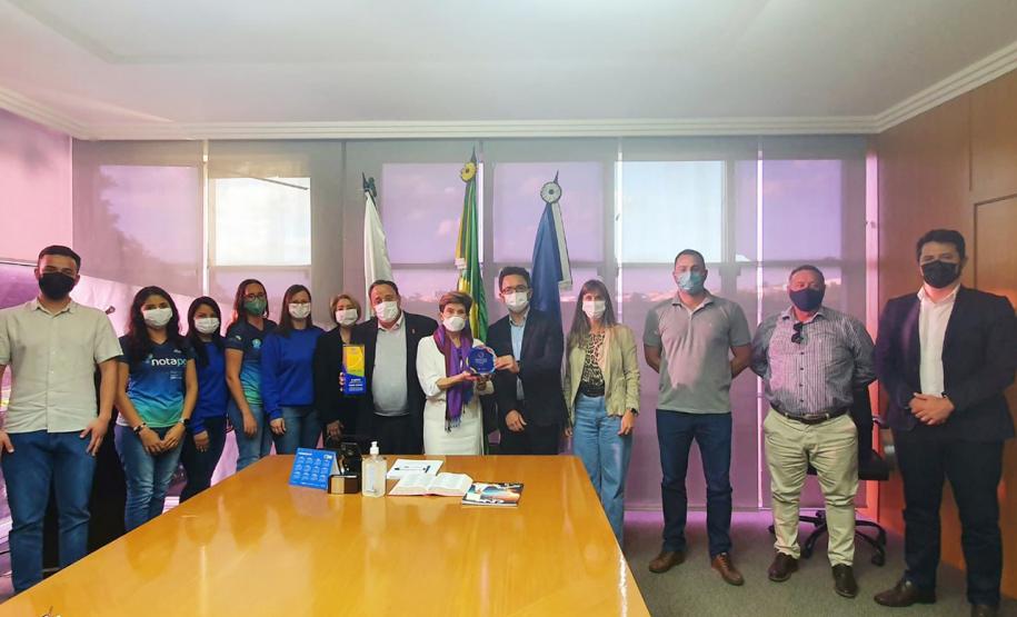 Fotografia em grupo. Ao centro estão o diretor-presidente da Fomento Paraná e a prefeita de Ponta Grossa.