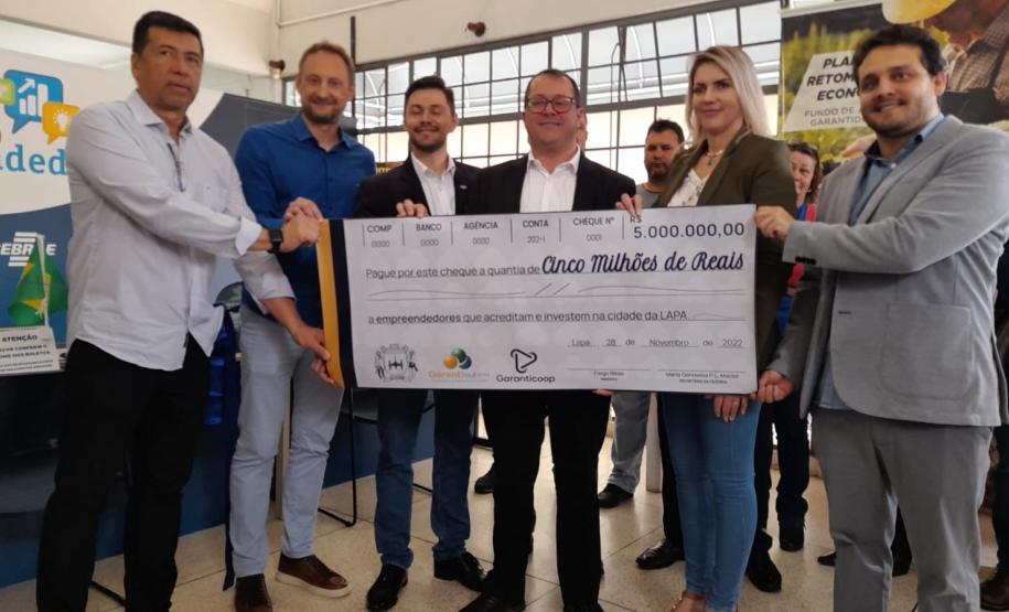 Grupo de pessoas mostra cheque gigante de R$ 5 milhões de reais