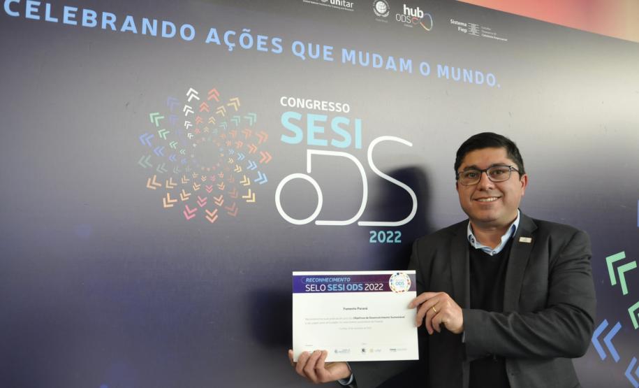 O gerente de Mercado da Fomento Paraná, Luciano Martins, mostra certificado de participação no Prêmio Sesi ODS 2022.