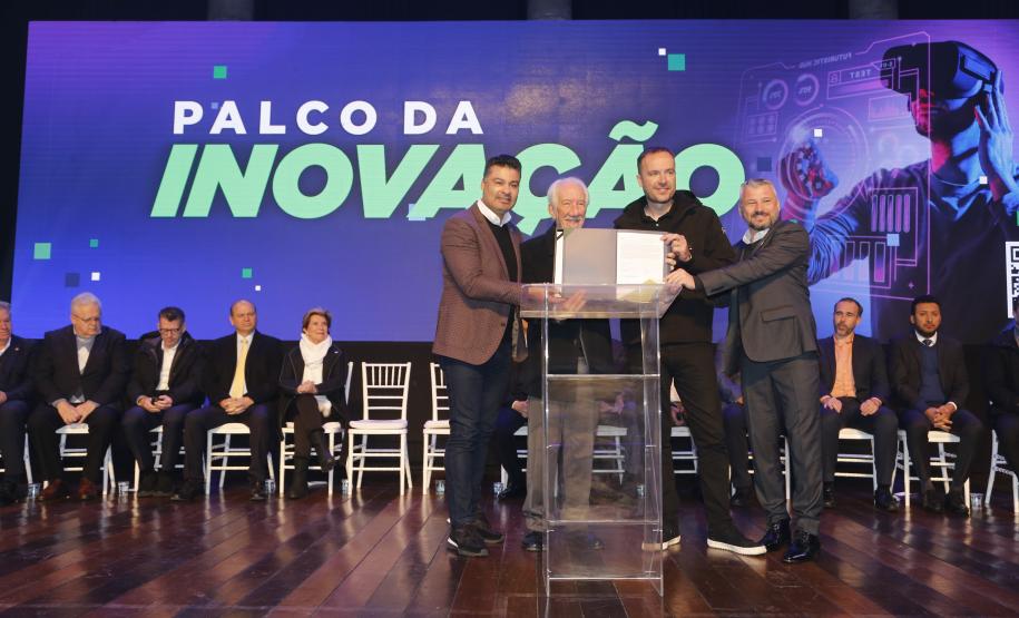 O empresário Marcio Léo Danielewicz, da SYX Global, assinou o contrato junto com o vice-governador Darci Piana, o secretário estadual de Inovação, Marcelo Rangel, e o diretor de Operações do Setor Privado da Fomento Paraná, Renato Maçaneiro.