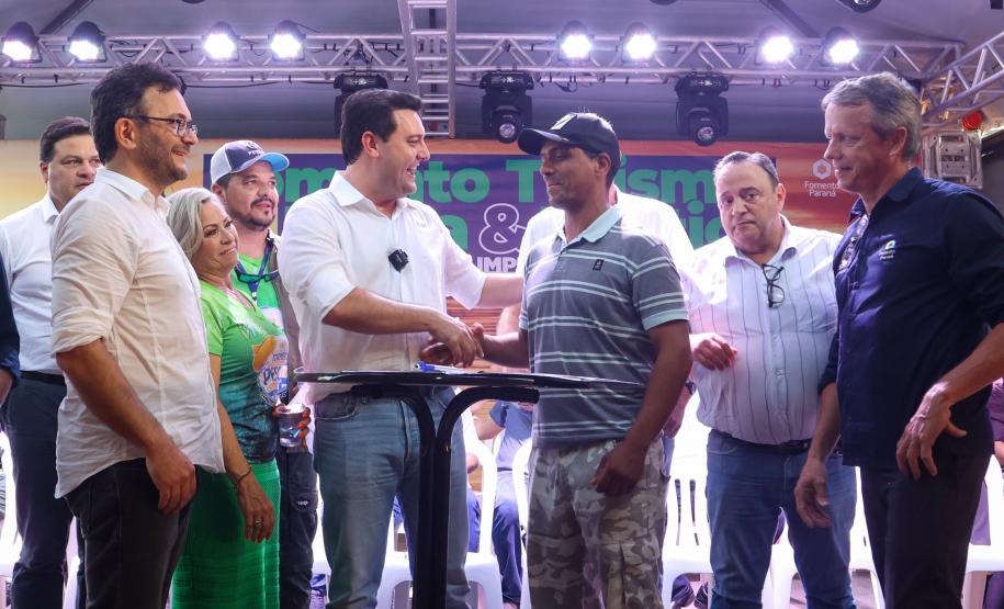 O governador Carlos Massa Ratinho Junior cumprimenta o pescador Edvaldo dos Santos, morador de Foz do Iguaçu, que assinou o primeiro contrato da linha Fomento Turismo, Pesca e Náutica.