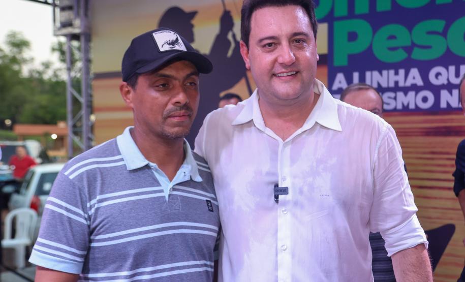 O governador Ratinho Júnior posa para foto com o pescador Edvaldo dos Santos, beneficiado com o primeiro financiamento da nova linha de crédito Fomento Turismo, Pesca e Náutica.