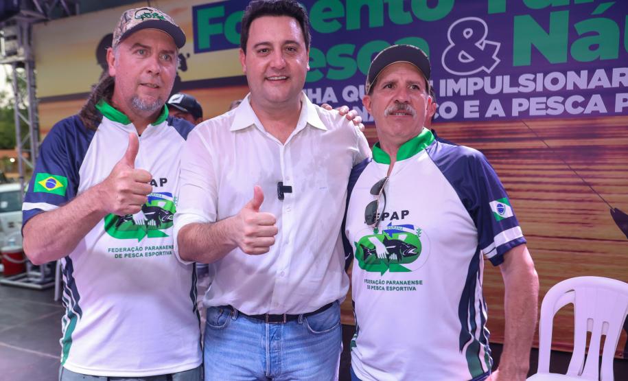 O governador Ratinho Júnior posa para foto com os dirigentes da Federação Paranaense de Pesca Esportiva, Antonio Edi Rauchbach Junior e Hélio Zanella.