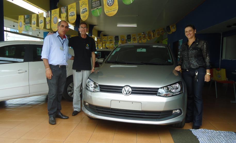 Agente de crédito Reinaldo Ribeiro acompanha os taxistas Estevan Cezar de Oliveira e Rosinei Veronez de Aguiar ao receberem as chaves dos novos veículos.