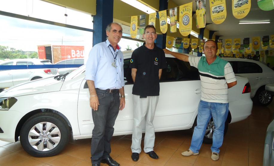 Agente de crédito Reinaldo Ribeiro acompanha os taxistas Estevan Cezar de Oliveira e Rosinei Veronez de Aguiar ao receberem as chaves dos novos veículos.