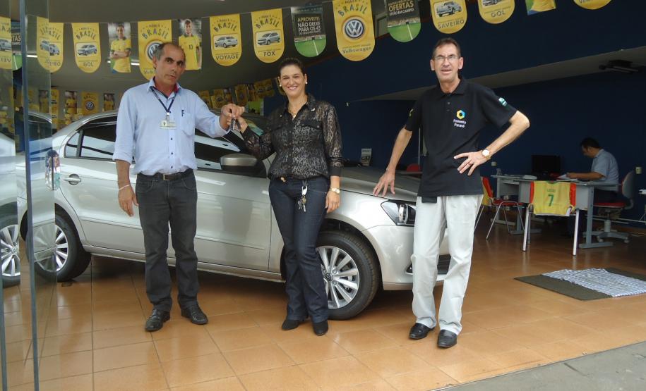 Agente de crédito Reinaldo Ribeiro acompanha os taxistas Estevan Cezar de Oliveira e Rosinei Veronez de Aguiar ao receberem as chaves dos novos veículos.